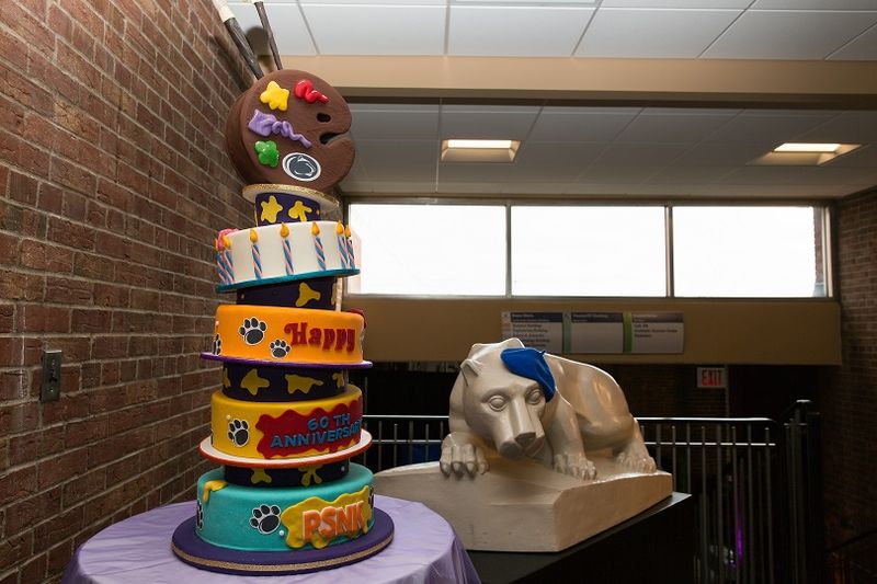 Penn State New Kensington 60th anniversary cake next to statue
