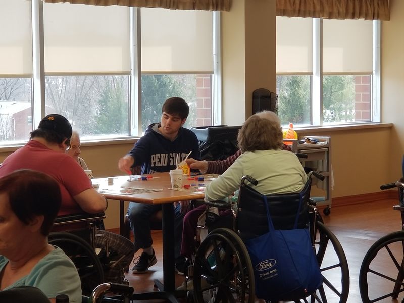 New Kensington student sits at table with Seneca Place residents to play Bingo