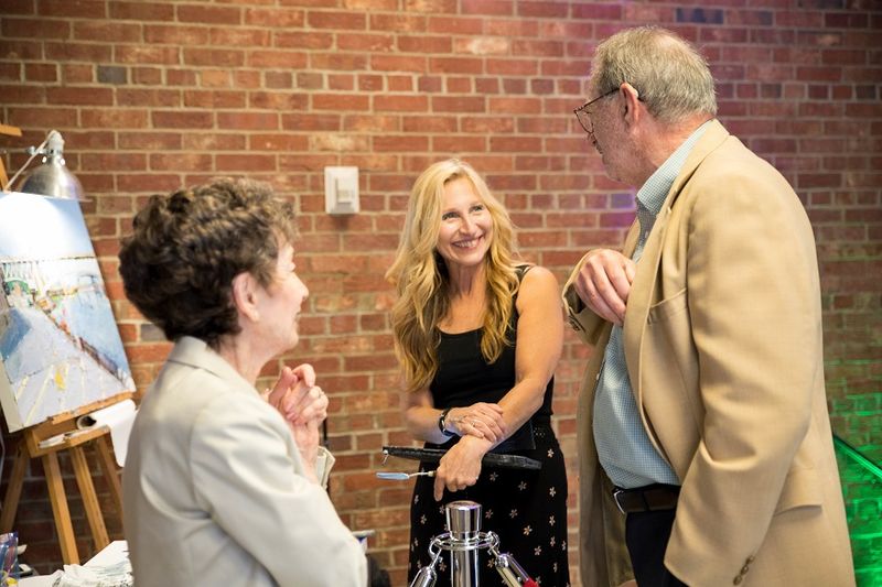 Joyce Werwie Perry, painter, speaks with guests at the 2018 Off the Wall pARTy