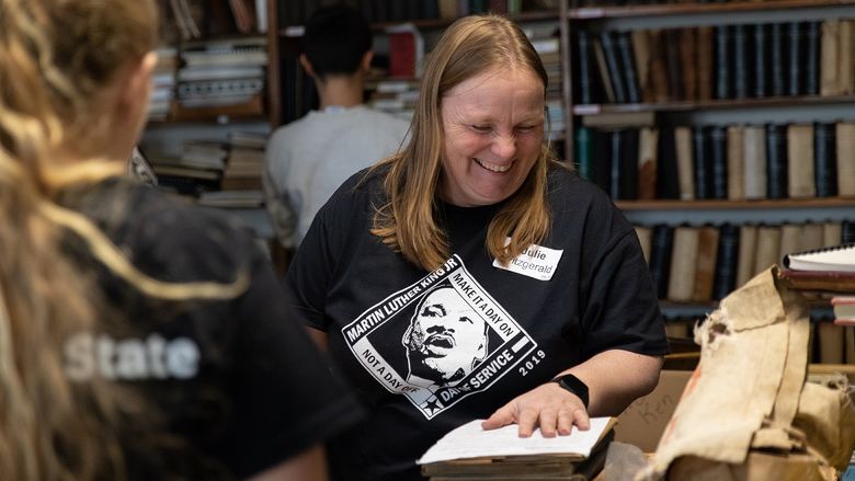 Woman moves books while smiling
