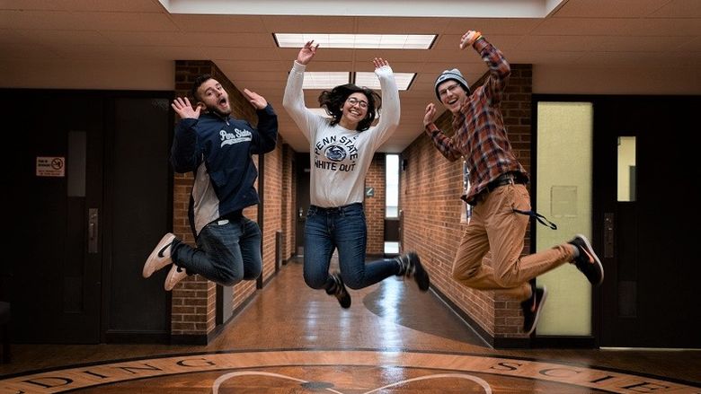 Three students jump in the air