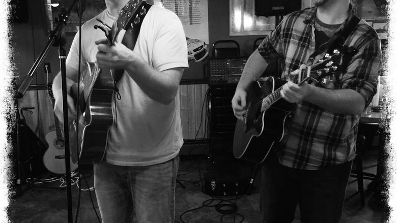 Two men playing guitar and singing