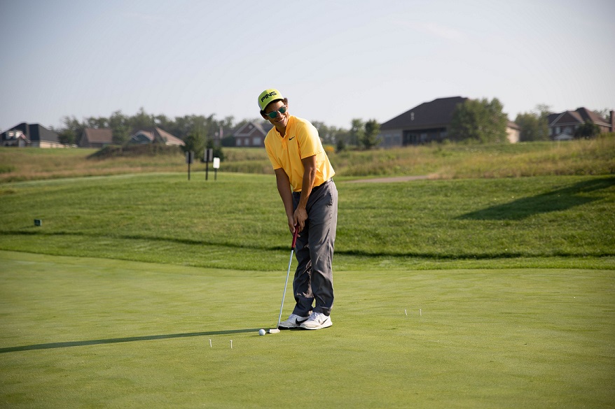 Golfer putts at golf outing