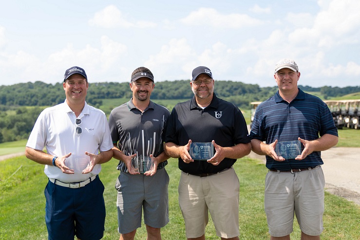 Four golfers holding trophies