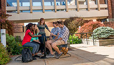 Seven students gathered around a table socializing