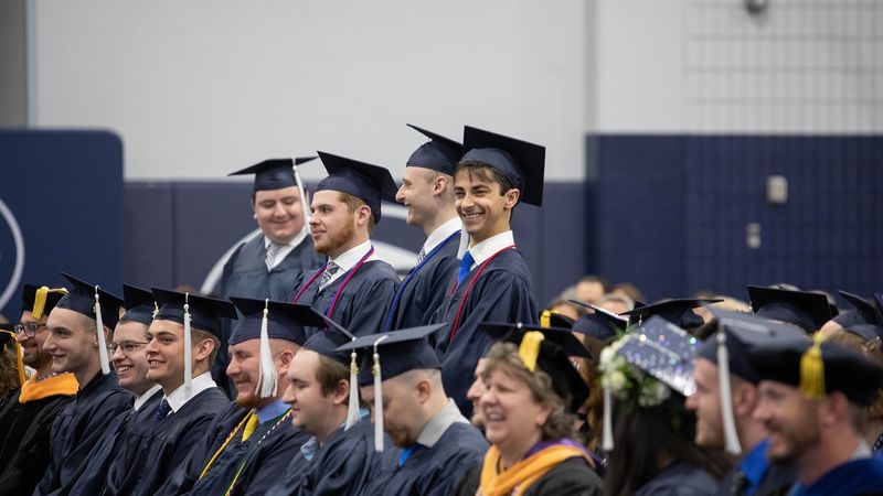 Four graduates standing and smiling