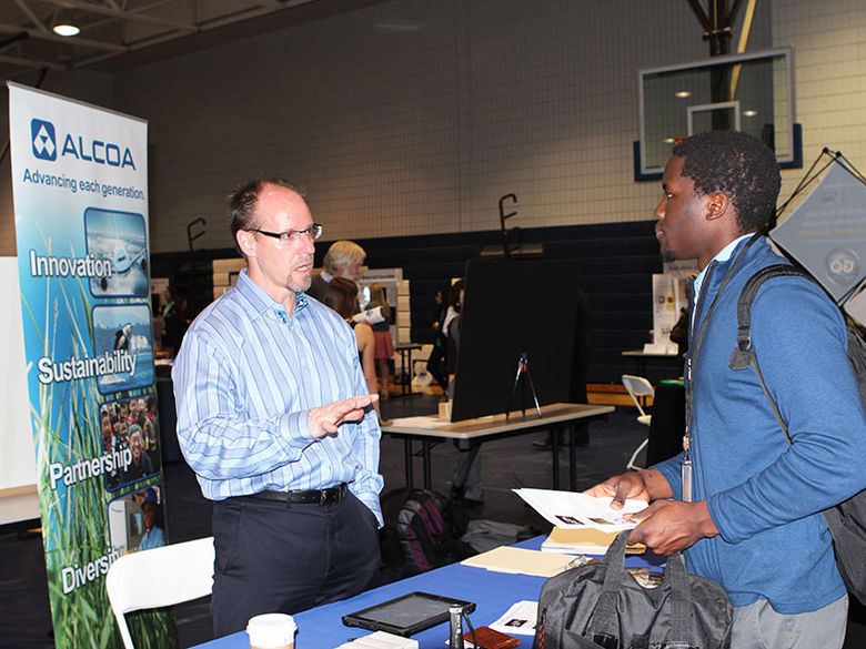 A corporate recruiter meets with an individual at a Career Fair
