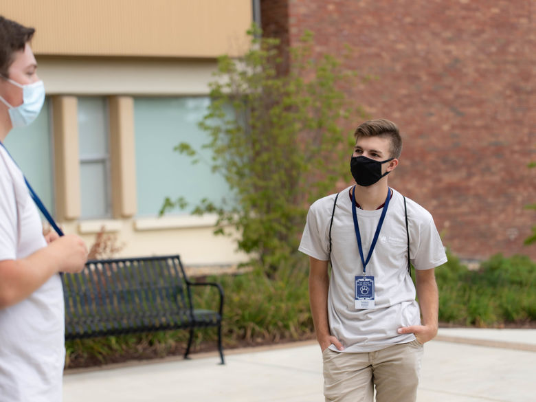 Two students outside wearing masks