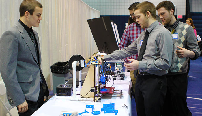 Students demonstrate a 3D printer they built