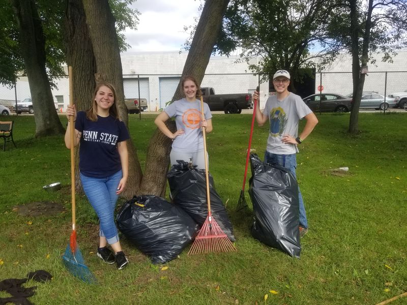 Students stand with lawn equipment