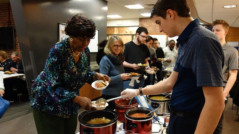 Student serves food to community member at New Kensington