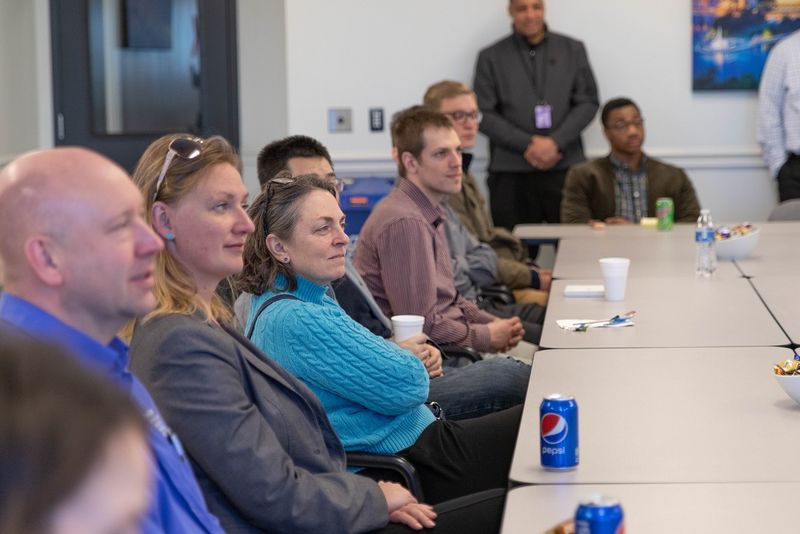 Men and women sit in conference room