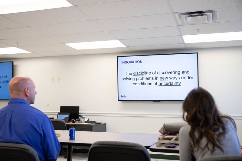 A presentation screen shows definition of "innovation" A presentation screen shows definition of "innovation"