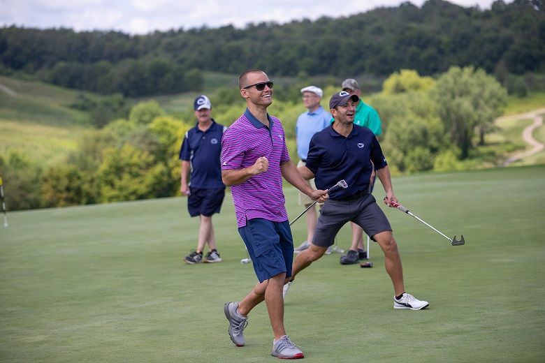 Man smiles holding golf putter Man smiles holding golf putter