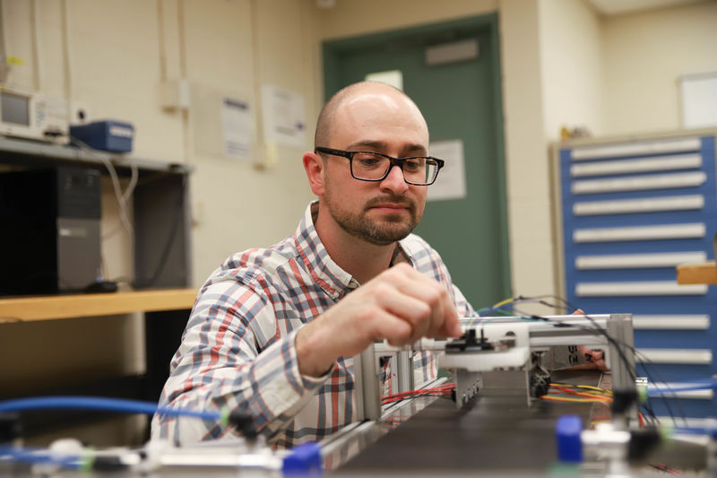Joseph Cuiffi wiring conveyor belt in lab Joseph Cuiffi wiring conveyor belt in lab