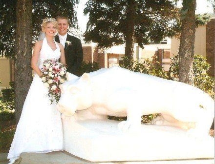 Bride and groom stand next to lion statue 