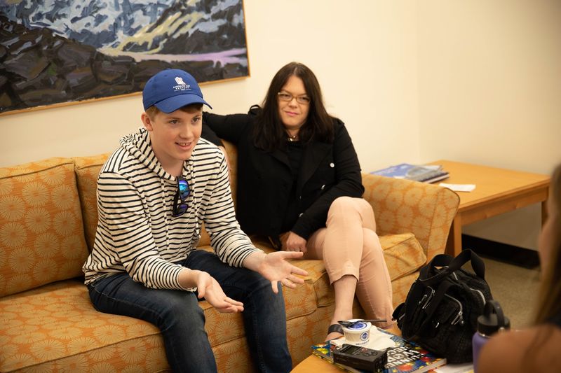 Mackinly Adams and his mother, Kelly, talking in library