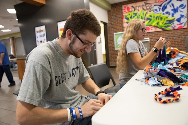 Students making dog toys from recycled shirts