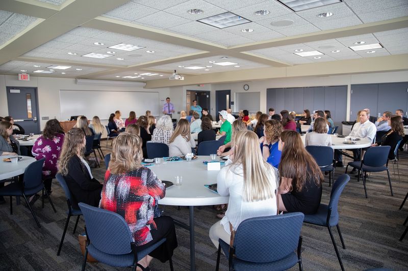 People sitting at tables in large conference center