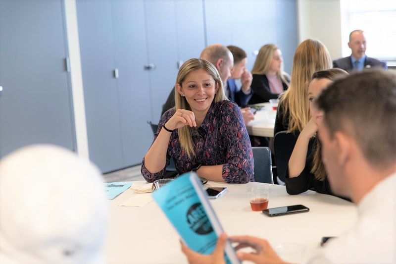 Female smiles while sitting at table