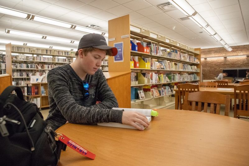 Mackinly Adams sitting in library