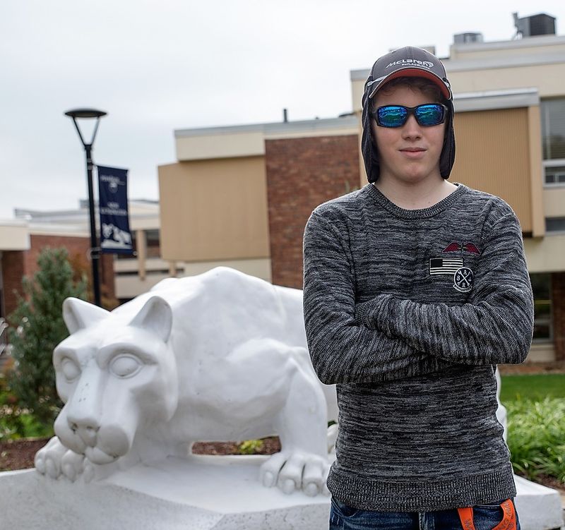 Mackinly Adams stands by lion statue