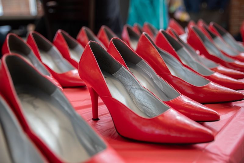 Two rows of red high heels on table