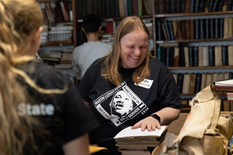 Woman moves books while smiling