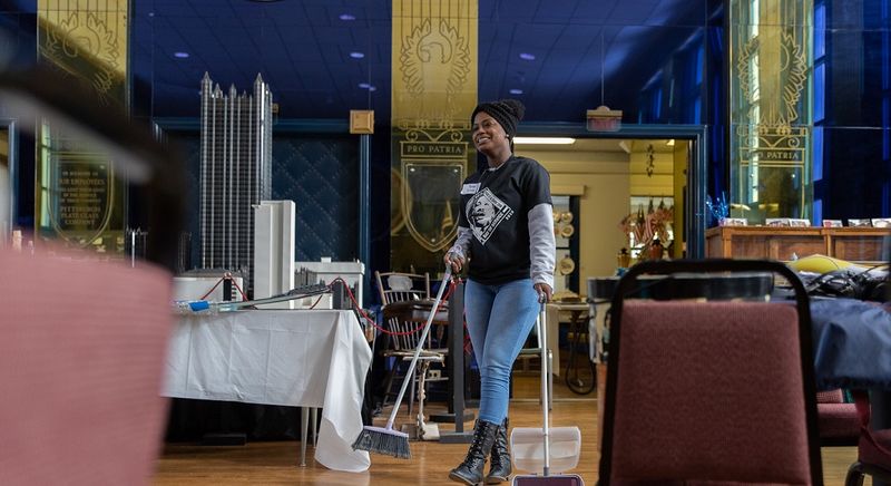 Student sweeps floor at museum