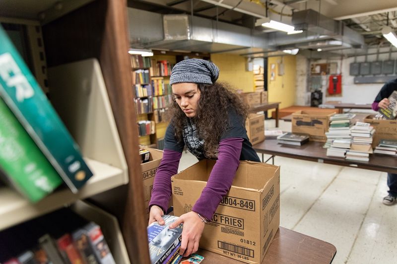 Student putting books into boxes Student moves books