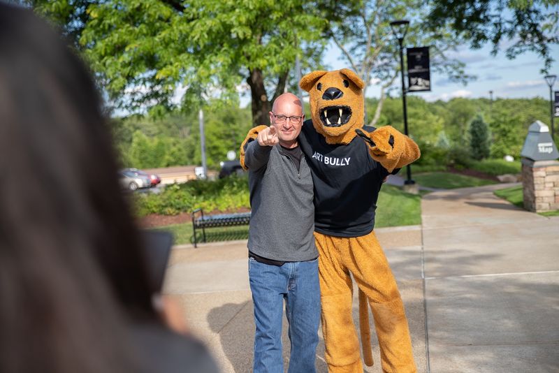 Man stands next to Nittany Lion mascot