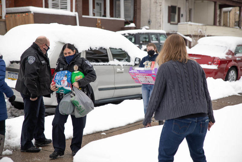 Individuals carrying gift bags and items