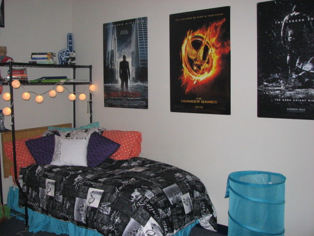 A bedroom with a bed and posters on the wall.