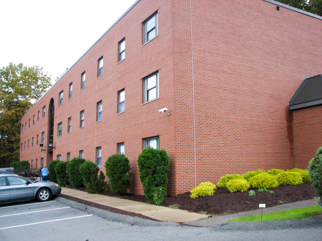 The red brick building exterior and well maintained landscaping