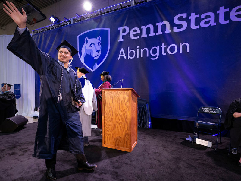 Student waves after accepting bachelor's degree