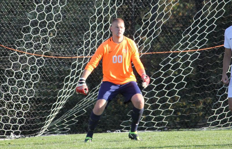 Man stands in front of soccer goal net