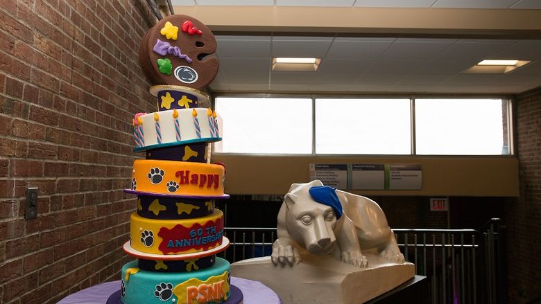 Penn State New Kensington 60th anniversary cake next to statue