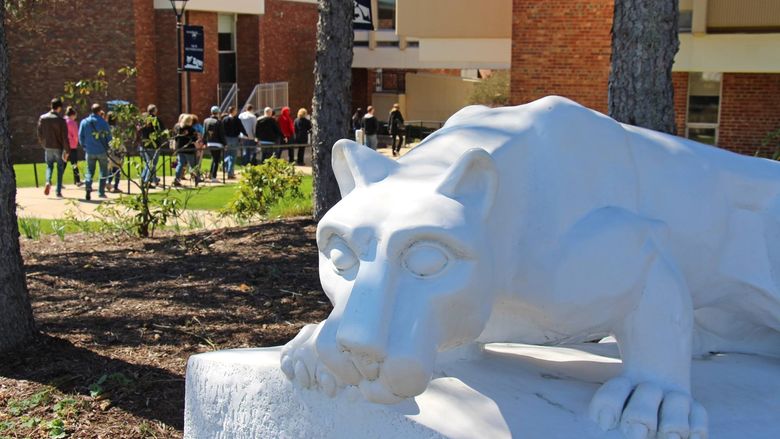 Tour group passes behind lion shrine at Penn State New Kensington