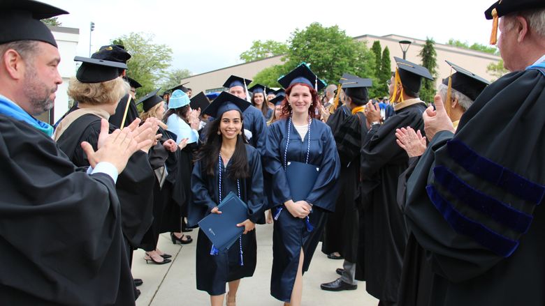Humanities, Arts and Social Sciences (HASS) Student Marshal Adriana Perez Camacho (left) and Science Student Marshal Laura Post led their divisions out of the Beaver Community Center following the HASS and Science Commencement Ceremony on May 6, 2017.