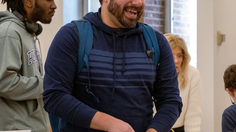 A student smiles while walking through the library during the Financial Literacy event.