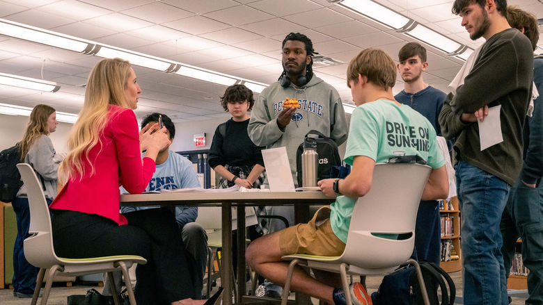 A group of students listen to Erin Weber during a roundtable session.