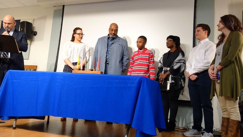 Campus and community members prepare to light the unity candle.