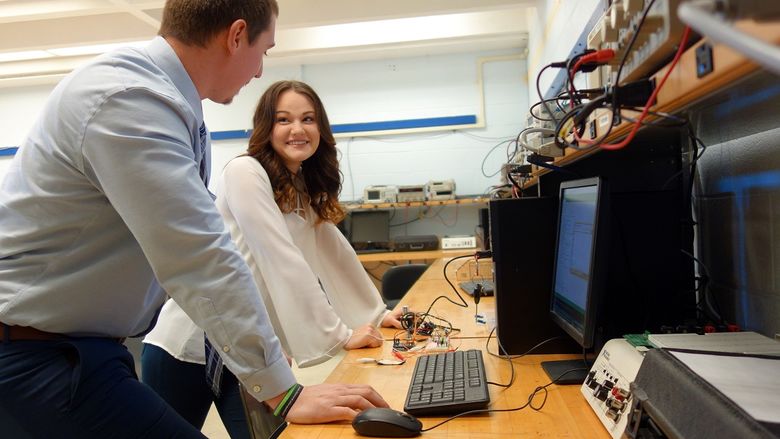 Olivia Sribniak smiles at project partner Anthony Gyke in engineering lab