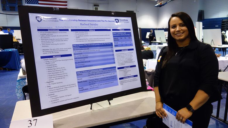 Racheal Sunday, student, stands next to her research poster