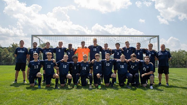 Soccer team stands in front of net for photo