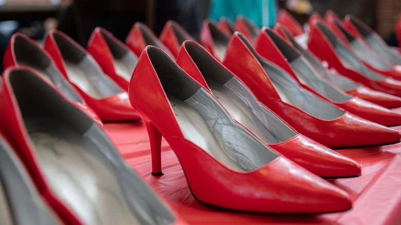 Two rows of red high heels on table