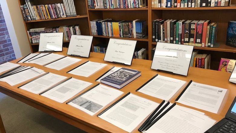 New Kensington faculty publications line a table in the library during annual celebration