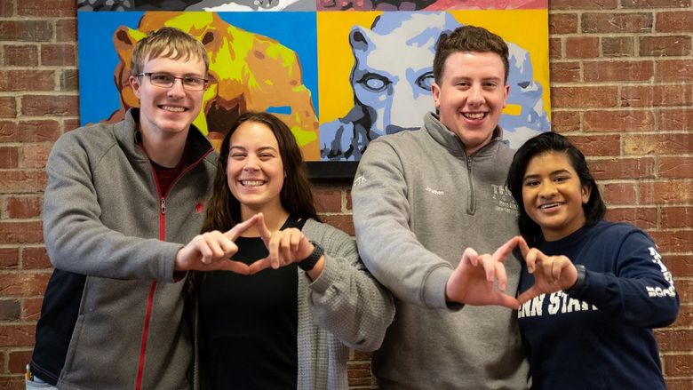 Four students stand and smile for photo