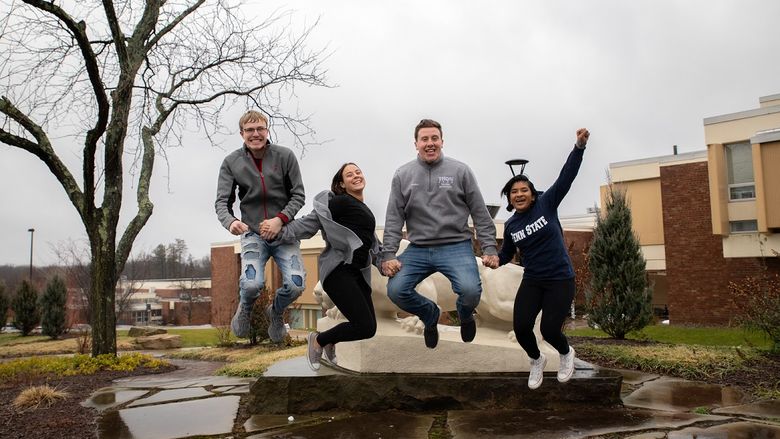 Four students jump in the air