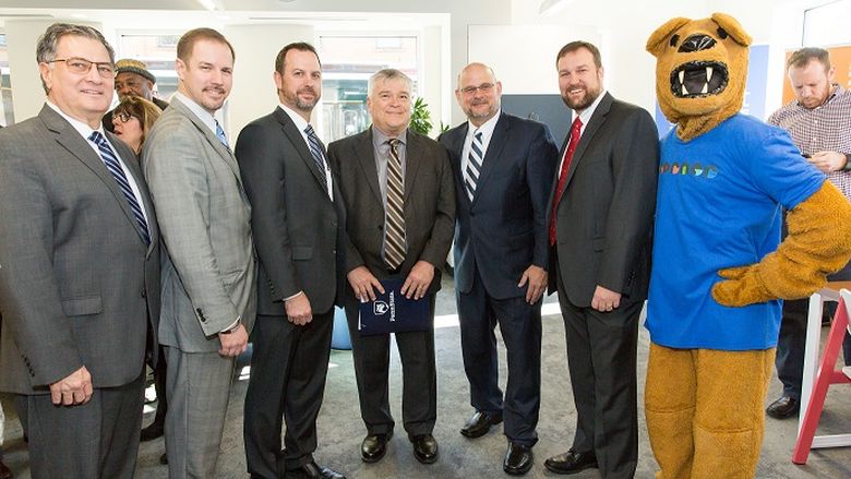 Penn State President Dr. Eric Barron is joined by Westmoreland County leaders for a photo at The Corner